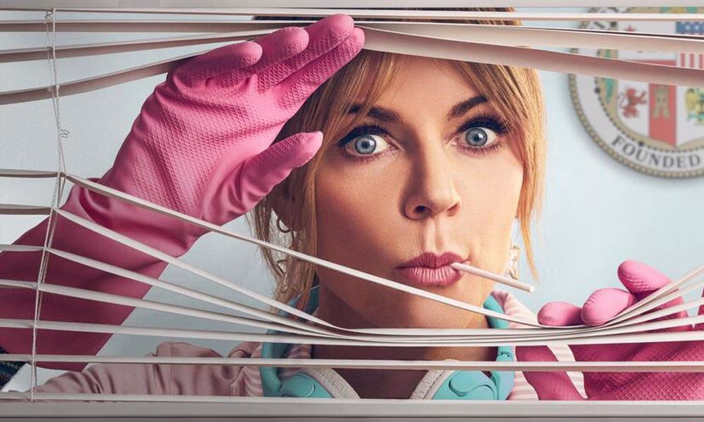 A blonde woman with a lollipop stick in her mouth and pink rubber gloves looks through an opening in window blinds, her eyes wide.