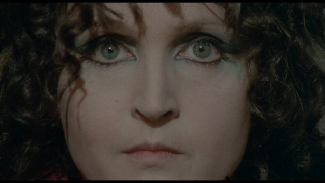 A close-up shot of a female psychic staring into the camera.