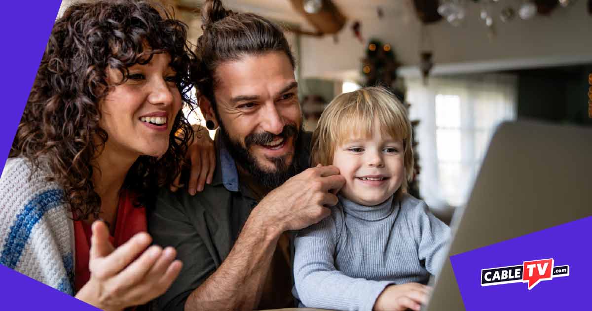 A family of three smiles, gathered in a cozy room as they enjoy watching something on their laptop, thanks to their reliable and cheap internet.