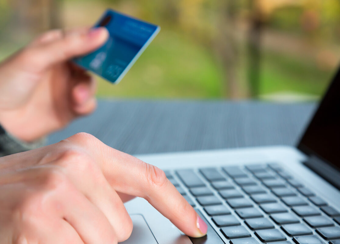 CTV_credit-card-online-shopping Person holding a credit card in one hand and typing on a laptop with the other