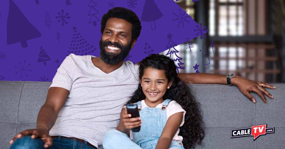 Smiling dad and daughter watching TV