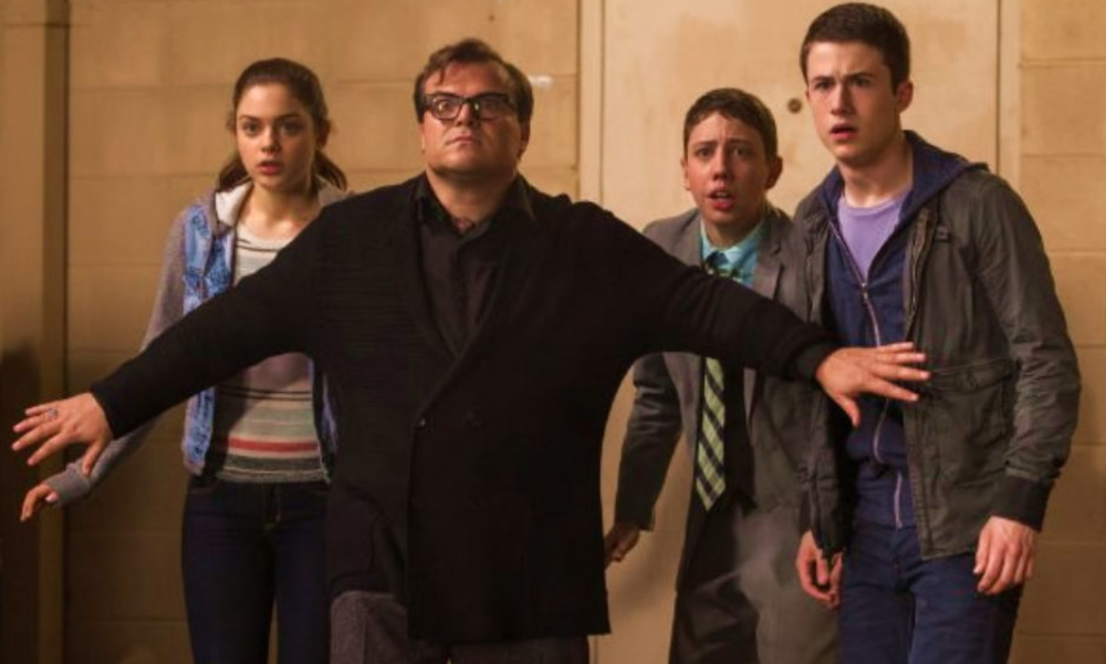Jack Black as R.L. Stine, standing between three teenagers and a spooky offscreen threat.