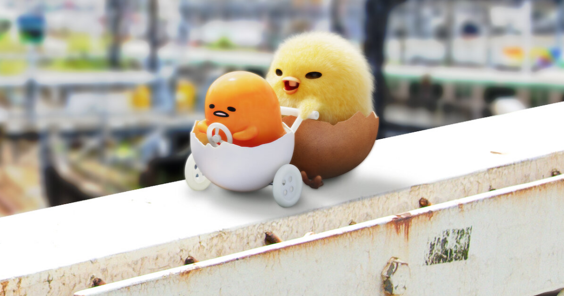 gudetama1200x630 Gudetama, an egg yolk with a face, being pushing in a half-shell stroller by a baby chicken.