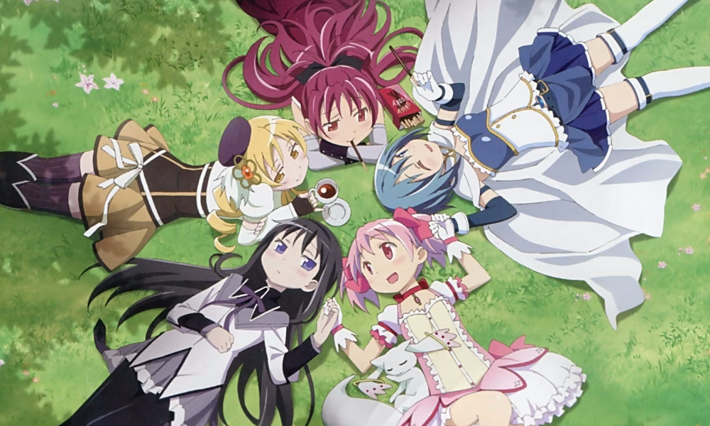 Five middle school girls wearing colorful dresses lie in a circle on a grassy background.