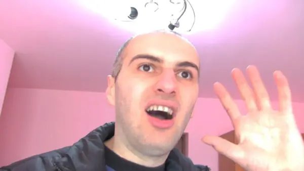 Image of a man in a pink room filming himself while talking and gesturing in Be My Cat: A Film for Anne