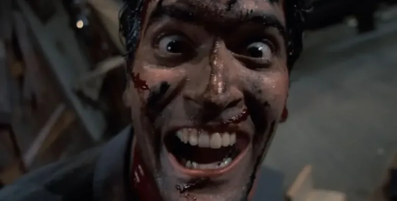 Image of the bloody face of a wild-eyed, possibly insane, man as trouble comes for him. A scene from Evil Dead II.