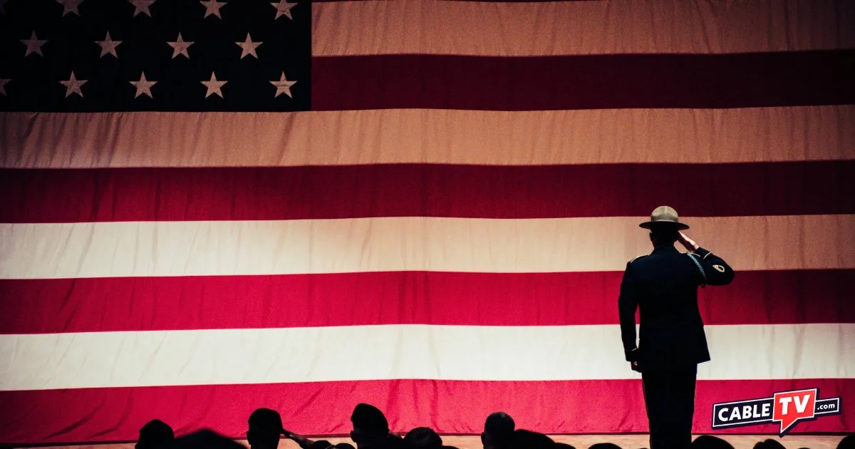 American flag backdrop with silhouette of serviceman in front giving a salute