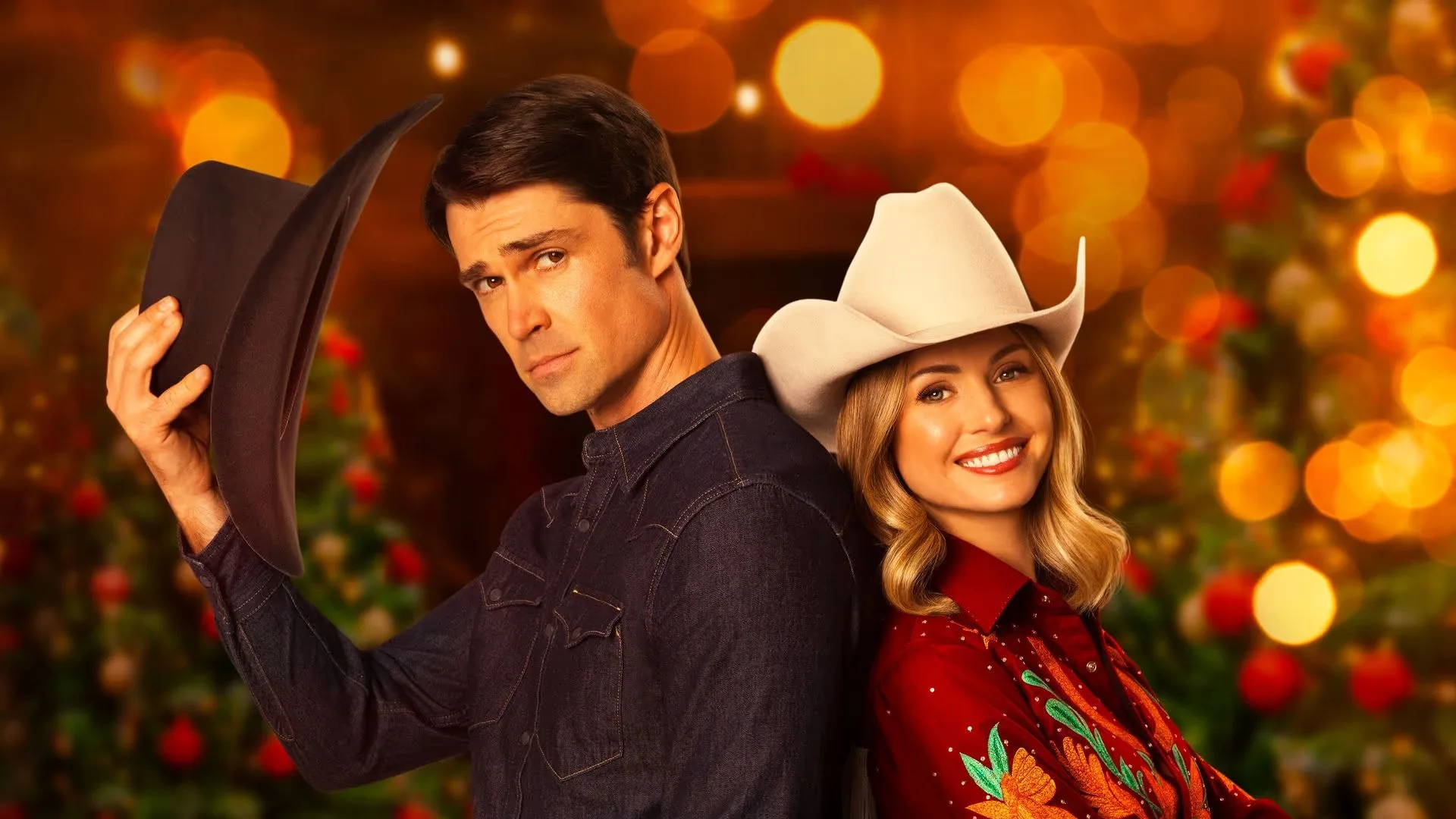 A scene from the Lifetime Christmas Movie, A Rodeo Christmas, shows a man and a woman standing back-to-back. The man is doffing his cowboy hat.
