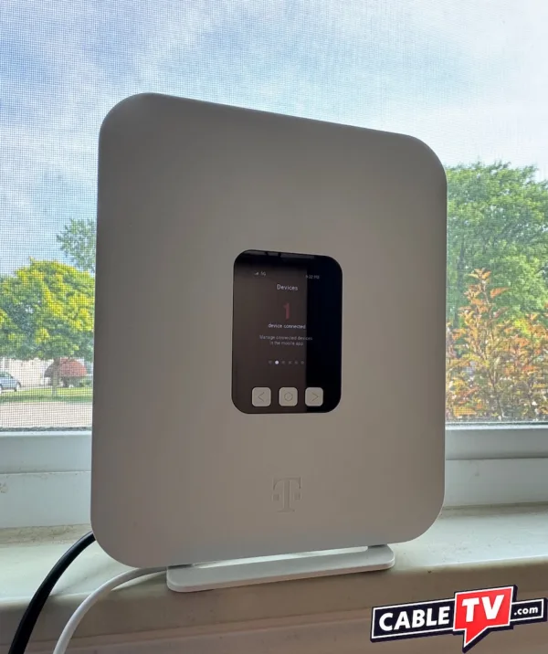 A T-Mobile 5G gateway placed on a sill in front of a large window.